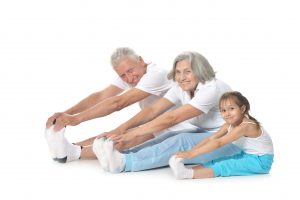 Senior couple exercising with granddaughter isolated on white background